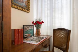 a table with a vase of flowers and books on it at at 2 minutes from San Marco square in Venice
