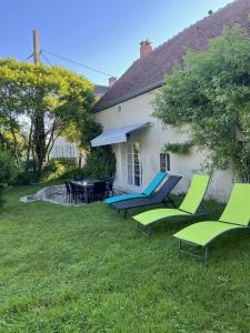 a group of chairs sitting in the grass in front of a house at Gîte du Bouloy in Montru +11 photos