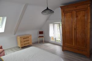 a bedroom with a bed and a dresser and a window at Jolie maison de campagne in Langueux
