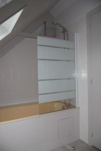 a bathroom with white walls and a window and a sink at Jolie maison de campagne in Langueux +8 photos