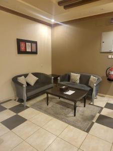 a living room with a couch and a coffee table at Safwt Aldyar Furnished Units in Abha