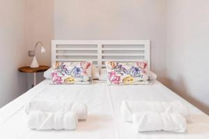 uma cama branca com lençóis e almofadas brancos em Minty Stay - Montera em Madri