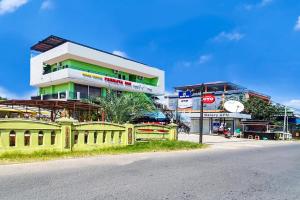 un edificio con una valla amarilla frente a una calle en Super OYO 90112 Hotel Permata Inn, en Banjarmasin