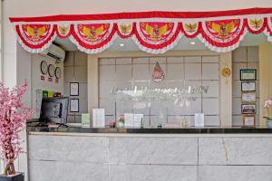 un frente de tienda con un dosel rojo sobre un mostrador en Super OYO 90112 Hotel Permata Inn, en Banjarmasin