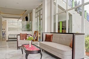 sala de estar con sofá y mesa en Super OYO 90112 Hotel Permata Inn, en Banjarmasin