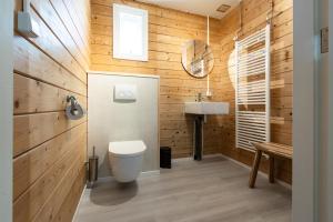 een badkamer met houten wanden, een toilet en een wastafel bij Chalet aan het water - vakantiepark de Schreiershoek in Dokkum