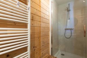 een badkamer met een douche en houten wanden bij Chalet aan het water - vakantiepark de Schreiershoek in Dokkum
