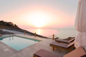 basen z widokiem na ocean o zachodzie słońca w obiekcie Live in Blue - Kea's Myriad Shades w mieście Korissia