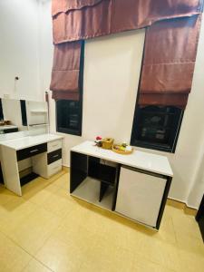 a kitchen with a table and two windows at Hue Happy Homestay in Hue