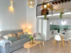 een woonkamer met een bank en een tafel bij Homely Málaga Loft Especerías in Málaga