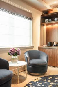 a living room with two chairs and a table and a window at Hotel 717 in Amsterdam