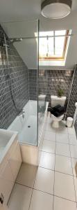 a bathroom with a shower and a tub and a toilet at The Apartment at St Georges Terrace in Cheltenham