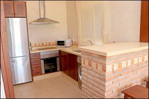 a kitchen with a refrigerator and a stove top oven at Chalet Ruperto in Conil de la Frontera