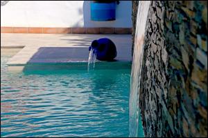 a fire hydrant in the middle of a pool of water at Bungalow La Roa IV in Conil de la Frontera