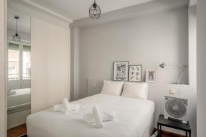 a white bedroom with a large white bed with white pillows at 2 bedrooms 1 bathroom furnished - Anton Martin - Vintage - MintyStay in Madrid