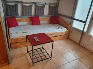 a small bed with a red table in a room at Le Gîte des Templiers à Montfort-sur-Argens in Montfort-sur-Argens