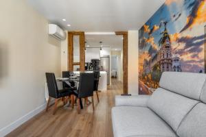 een eetkamer met een tafel en een bank bij 2 bedrooms 2 bathrooms furnished - Malasaña - bright and refurbished - MintyStay in Madrid