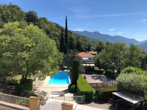 een villa met een zwembad en bergen op de achtergrond bij HOTEL ST SEBASTIEN in Roquebillière