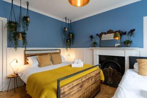 um quarto com paredes azuis, uma cama e uma lareira em 50TheHighstreet by The House of Danu em Kingussie