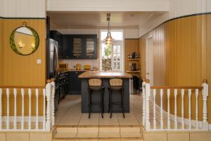 a kitchen with yellow walls and a kitchen island with bar stools at 50TheHighstreet by The House of Danu in Kingussie