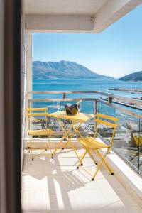a table and chairs on a balcony with a view of the water at Fontana Residence Budva in Budva