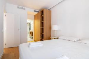 1 dormitorio con cama blanca y armario en 3 bedrooms 2 bathrooms furnished - Salamanca - Stylish - MintyStay, en Madrid
