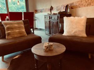 a living room with two couches and a table at La tanière Dinant in Dinant