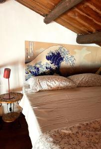 a bed with a large blue and white painting on the wall at Loft Aragonese in Palermo