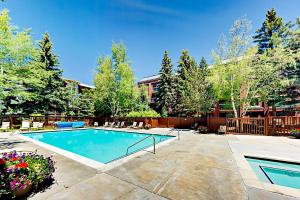 a swimming pool in a yard with trees and a building at Park Station Condominiums 234 in Park City