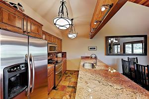 a kitchen with a stainless steel refrigerator and wooden cabinets at Lakeside Adventure in Park City