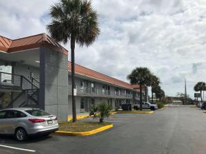 a car parked in a parking lot in front of a motel at Suburban Studios North Charleston I-526 in Charleston