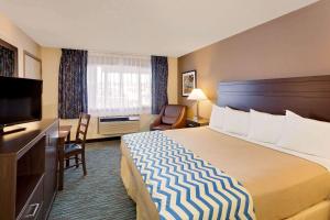 アバディーンにあるTravelodge by Wyndham Aberdeenの大型ベッドとテレビが備わるホテルルームです。