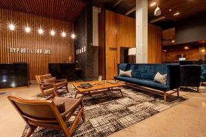 uma sala de estar com um sofá, cadeiras e uma mesa em TRYP by Wyndham San Luis Potosi Hotel & Suites em San Luis Potosí