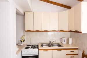 una cucina con armadi bianchi e lavandino di Apartment Nadalina a Dubrovnik