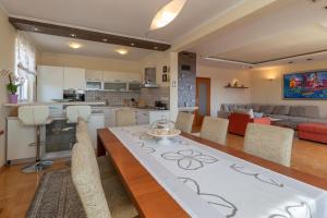 a kitchen and living room with a table and chairs at SEA VIEW- spacious apartment with shared pool in Split