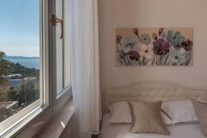 a bed in a room with a window and a picture at SEA VIEW- spacious apartment with shared pool in Split