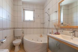 a bathroom with a tub and a toilet and a sink at SEA VIEW- spacious apartment with shared pool in Split