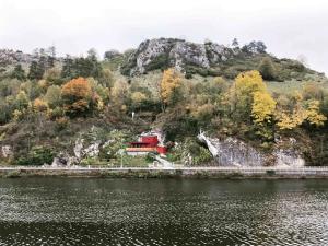 a house on a hill next to a body of water at La tanière Dinant in Dinant