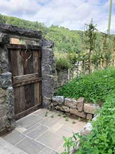 an old wooden door with a heart on a stone wall at La tanière Dinant in Dinant