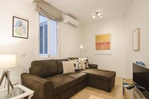 uma sala de estar com um sofá castanho e uma janela em 1 bedroom 1 bathroom furnished - Chamberi - Cozy - MintyStay em Madri