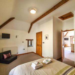 ein Schlafzimmer mit einem Bett und einer Couch in einem Zimmer in der Unterkunft Ta Mill Cottages & Lodges - Hayloft Cottage in Launceston