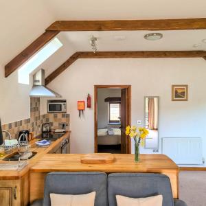 Ta Mill Cottages & Lodges - Hayloft Cottage في لاونسستون: مطبخ مع طاولة خشبية في الغرفة