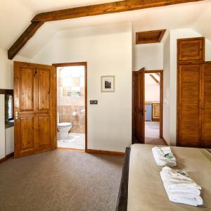 a bedroom with a bed and a bathroom with a toilet at Ta Mill Cottages & Lodges - Hayloft Cottage in Launceston
