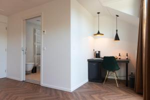 a room with a desk and a green chair at Herberg Restaurant 't Zwaantje in Mook +37 photos