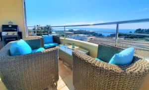 a balcony with two chairs and a table with blue pillows at SEA VIEW- spacious apartment with shared pool in Split