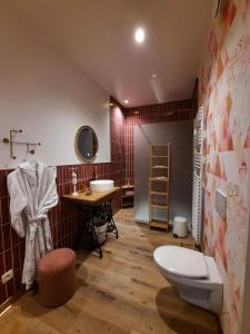 a bathroom with two sinks and a toilet in it at Avou nozôtes in Namur