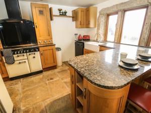 a kitchen with wooden cabinets and a counter top at Rake Hey Farm in Todmorden