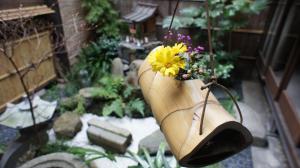 un vaso con un fiore giallo in un giardino di Inn Kawashima a Kyoto