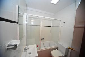 un bagno con doccia, WC e lavandino di Orange Park Duplex Familiar Jardin a Benicàssim Altre 6 foto