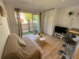 Schlafzimmer mit einem Bett, einem Schreibtisch und einem TV in der Unterkunft Studio proche de la plage de l'almanarre in Hyères